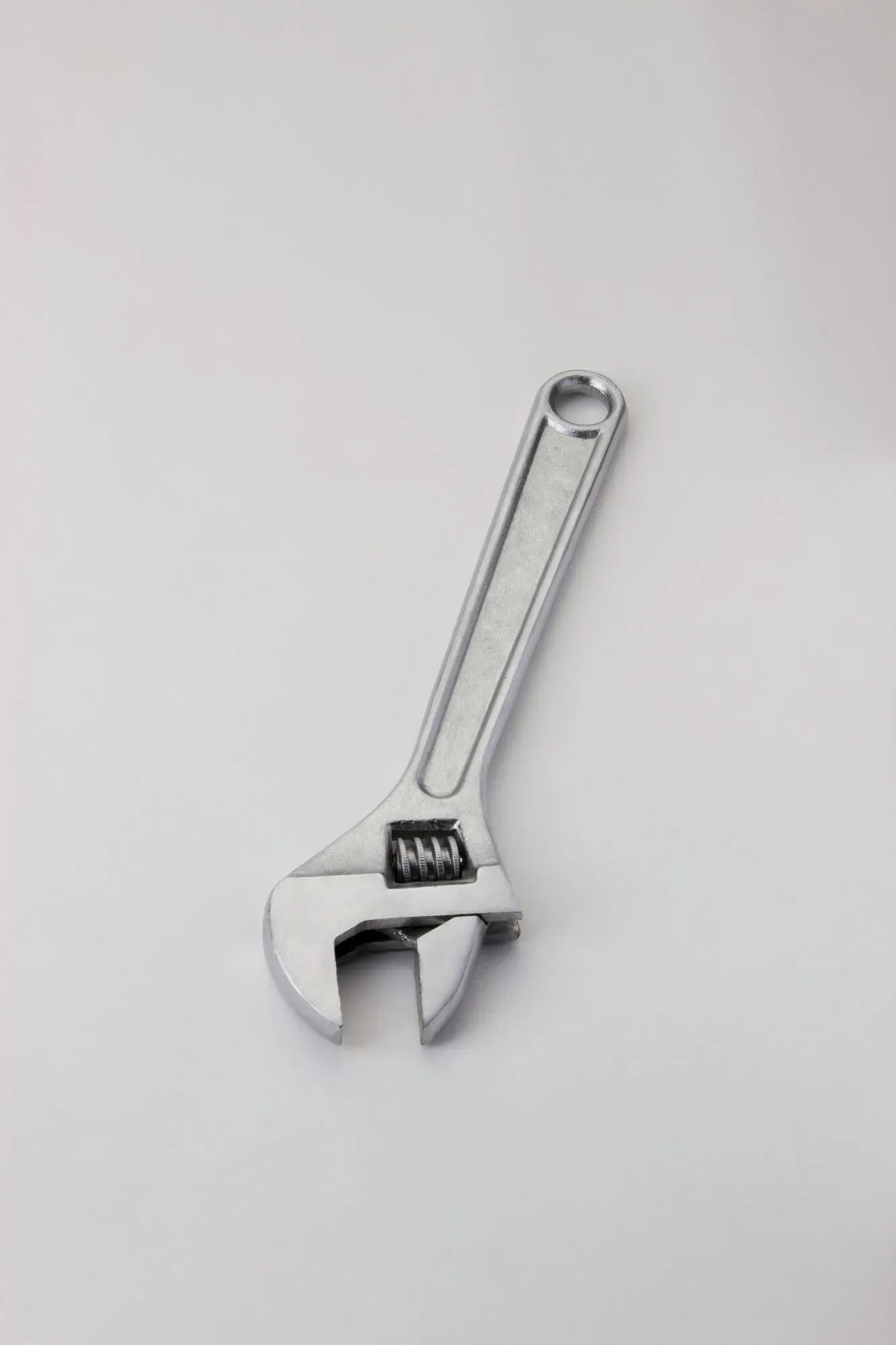Adjustable wrench on a plain background